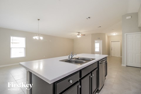 a large kitchen with a sink and a white counter top