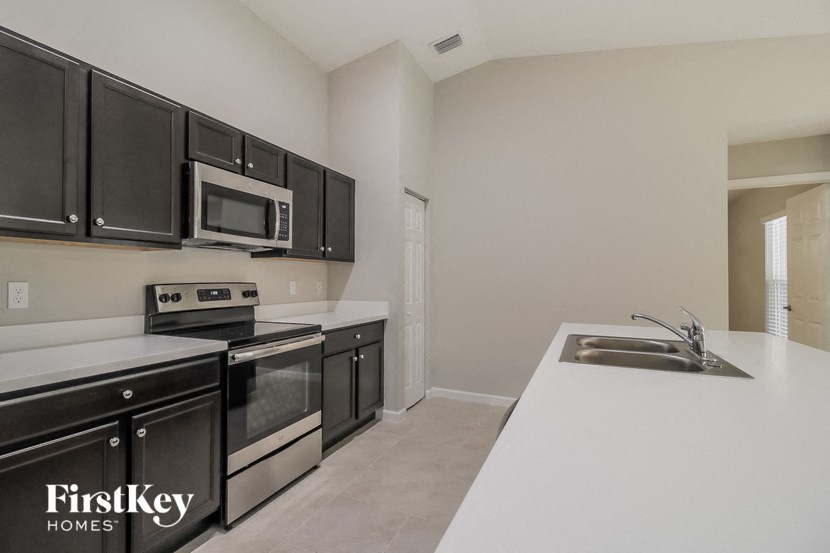 a kitchen with black cabinets and white counter tops and a sink