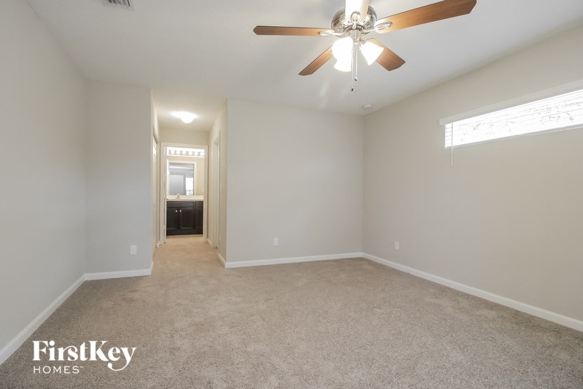 an empty living room with a ceiling fan