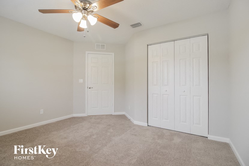 a bedroom with two closets and a ceiling fan