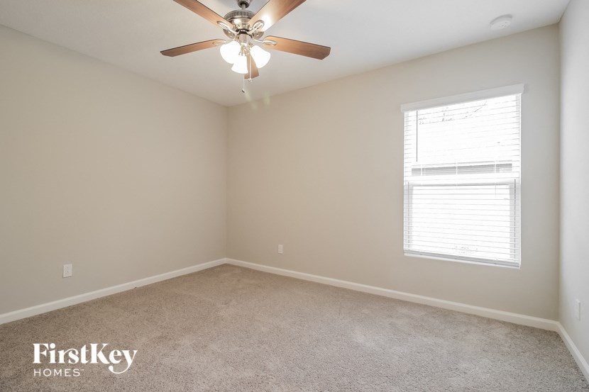 a bedroom with a ceiling fan and a window