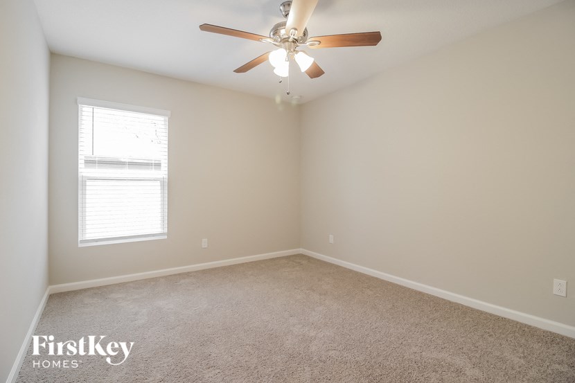 a bedroom with a ceiling fan and a window