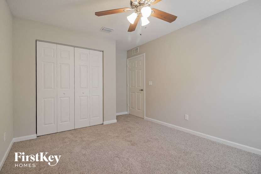 a bedroom with two closets and a ceiling fan