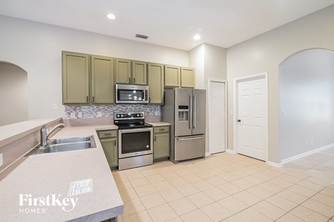 a large kitchen with stainless steel appliances and a sink