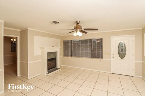 a living room with a fireplace and a ceiling fan
