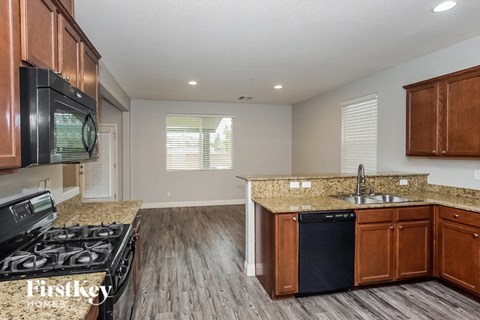 A kitchen with wooden cabinets and a black stove top oven.