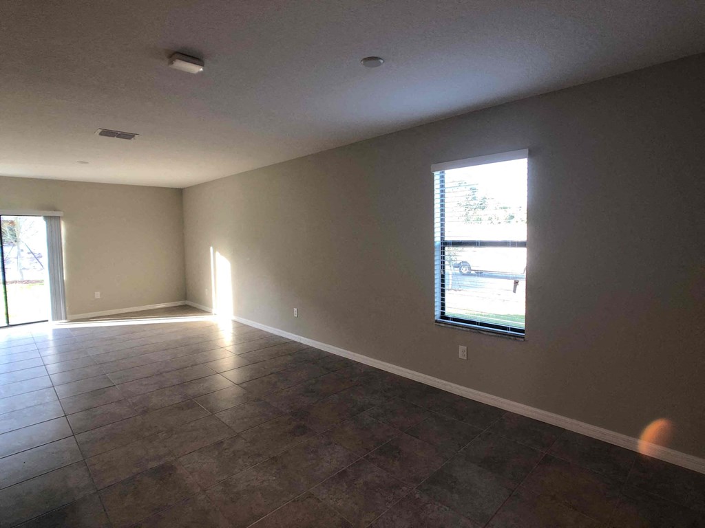 A room with a large window and a brown floor.