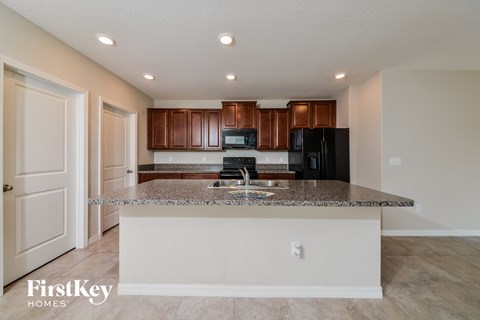 A kitchen with a granite countertop and a refrigerator.
