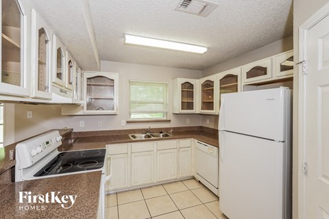 a white kitchen with white appliances and white cabinets