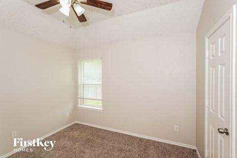 a bedroom with carpet and a ceiling fan