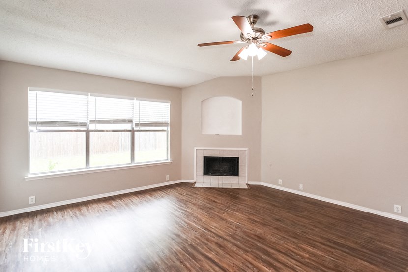 A room with a fireplace and a ceiling fan.