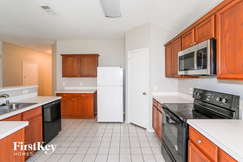 A kitchen with white appliances and wooden cabinets.