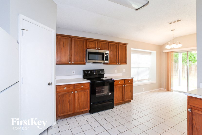 A kitchen with a black oven and white fridge.