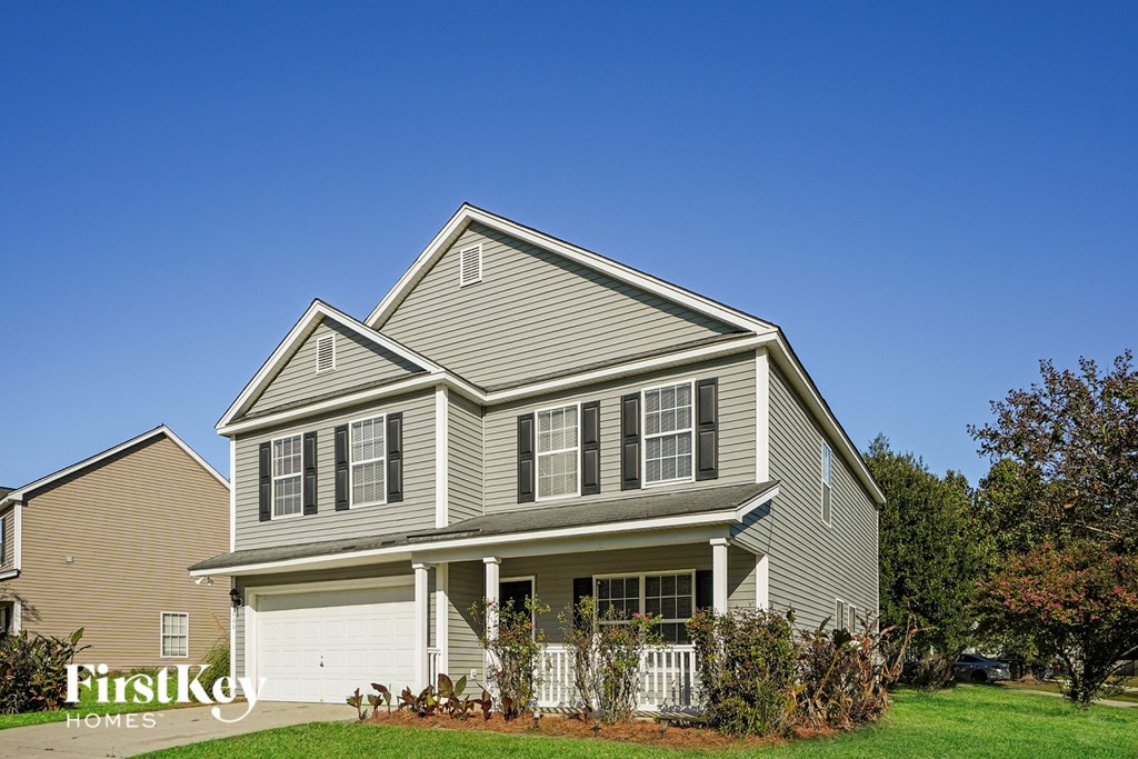 A house with a grey siding and a white garage door.