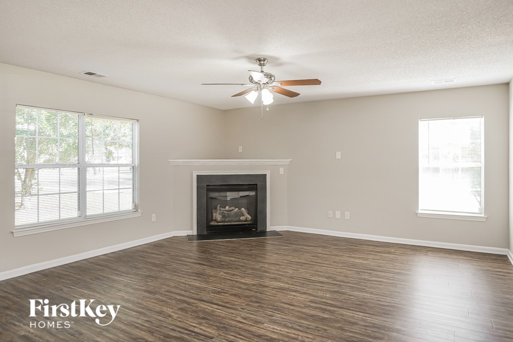 A spacious living room with a fireplace and wood flooring.