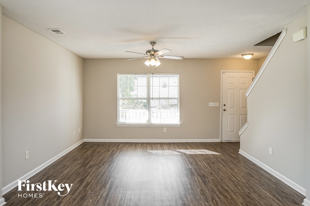 A room with wooden floors and a ceiling fan.