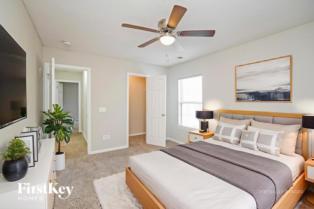 A bedroom with a large bed and a ceiling fan.