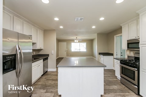 a kitchen with white cabinets and stainless steel appliances
