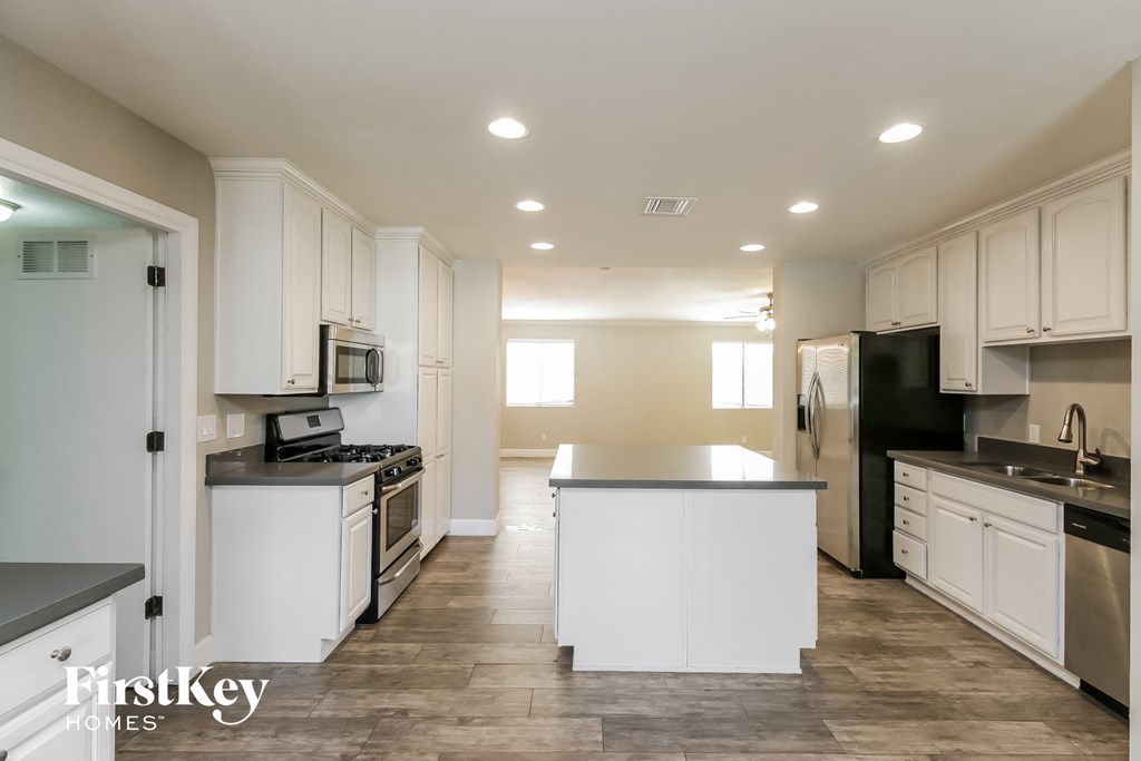 a large kitchen with white cabinets and stainless steel appliances