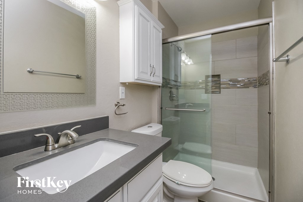 a white bathroom with a shower sink and toilet