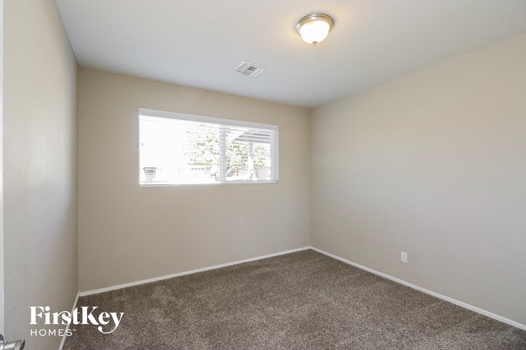 a bedroom with carpet and a window