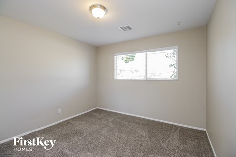 the spacious living room with carpet and a window