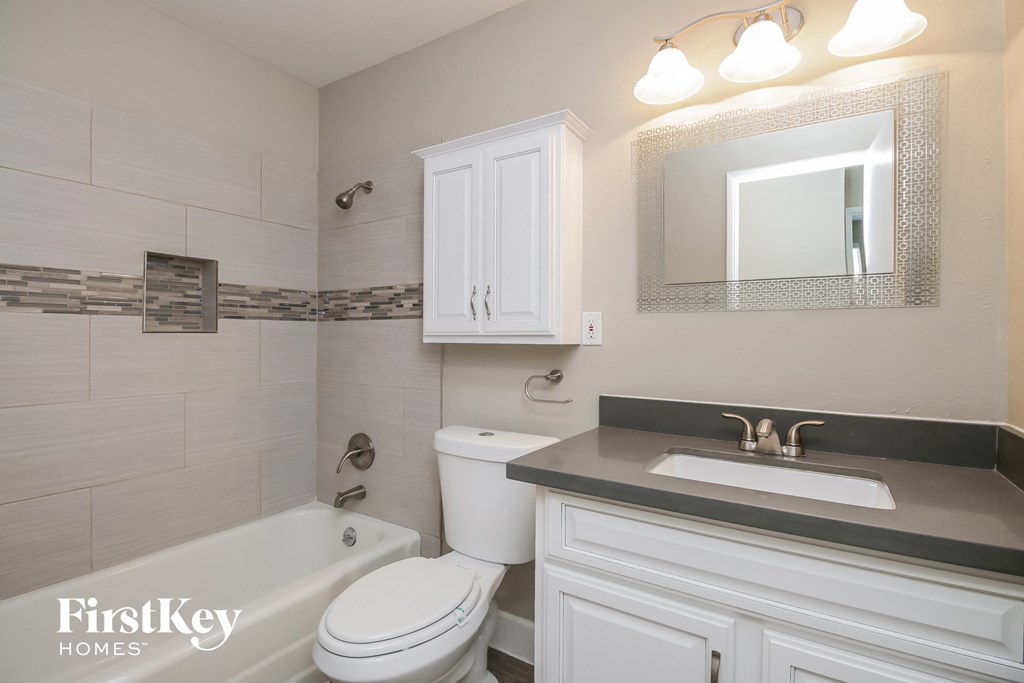 a white bathroom with a sink toilet and bath tub