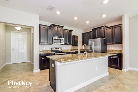 a kitchen with black cabinets and a granite counter top