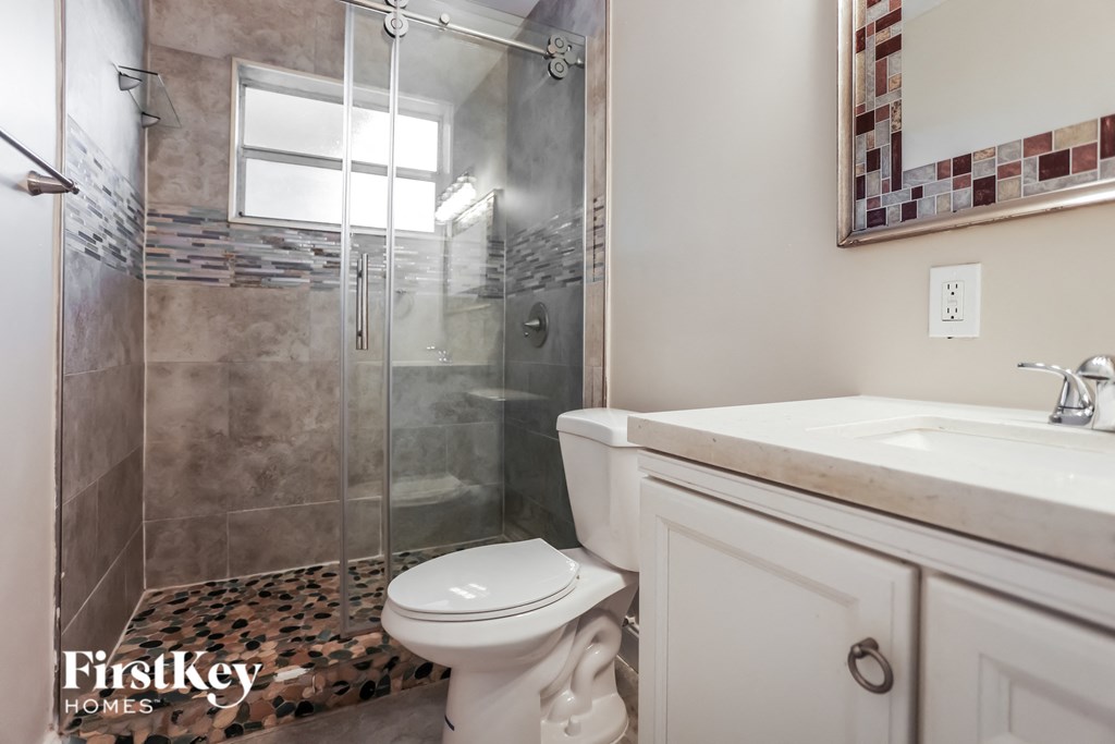 a bathroom with a shower and a sink and a toilet