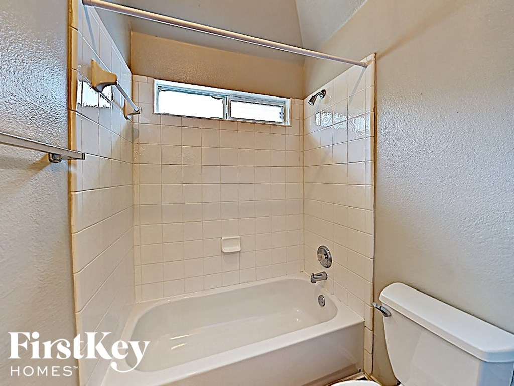 a white bathroom with a tub and a toilet