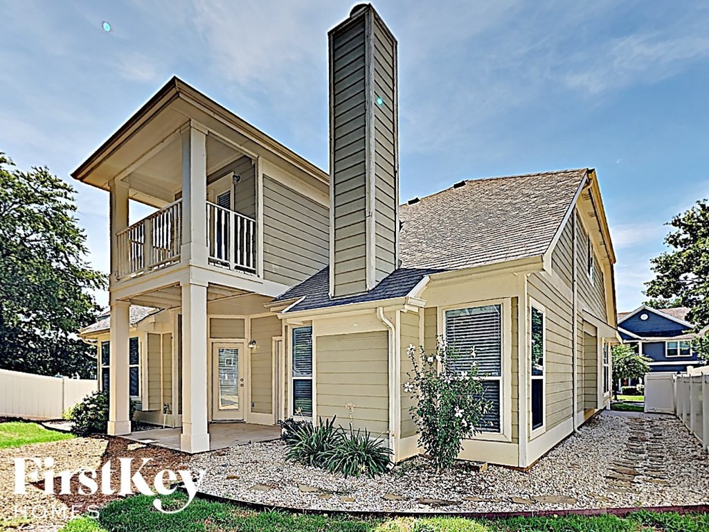 a tiny house with a porch and a steeple on top of it