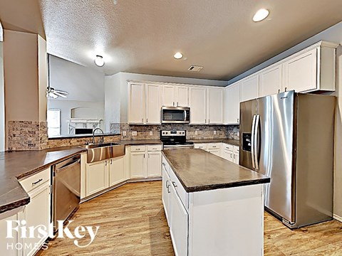 a large kitchen with stainless steel appliances and white cabinets