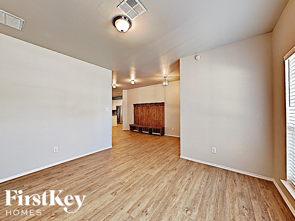 an open living room with a wood floor and a fireplace