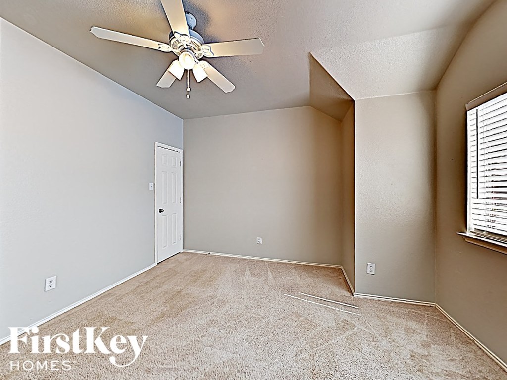 the living room of an empty house with a ceiling fan