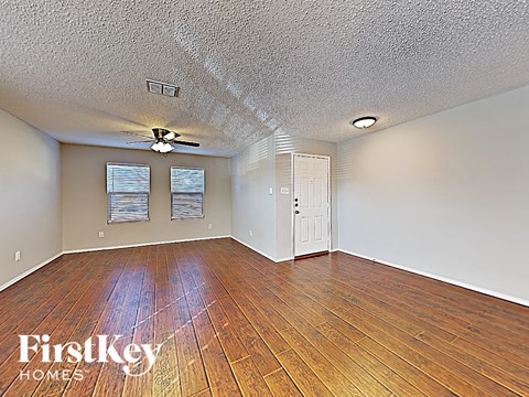 A room with wooden floors and a ceiling fan.