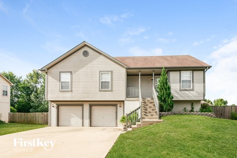 A two-story house with a garage and a front porch.