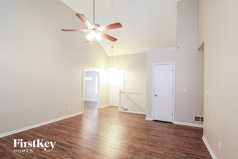 A spacious room with a ceiling fan and wooden flooring.