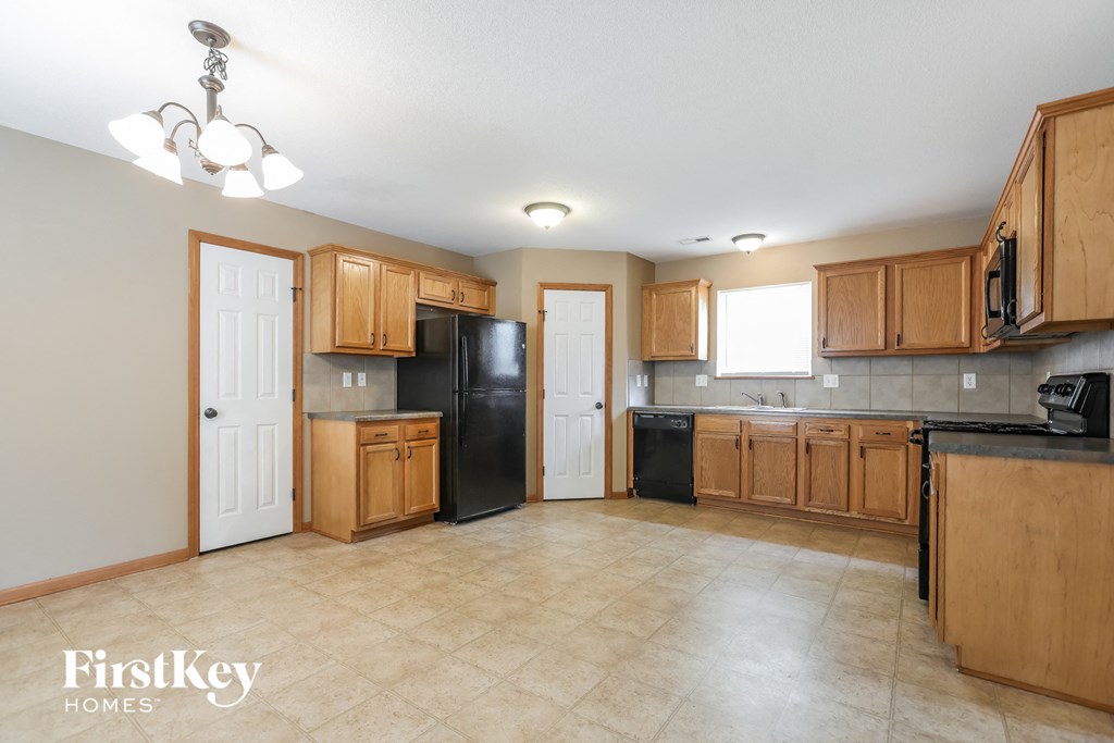 a kitchen with wooden cabinets and a black refrigerator