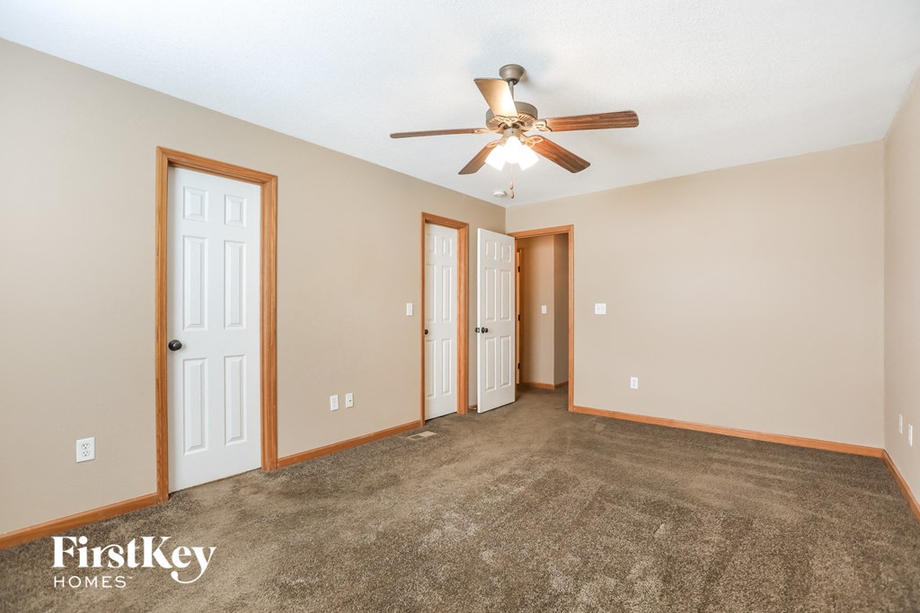 a living room with carpet and a ceiling fan