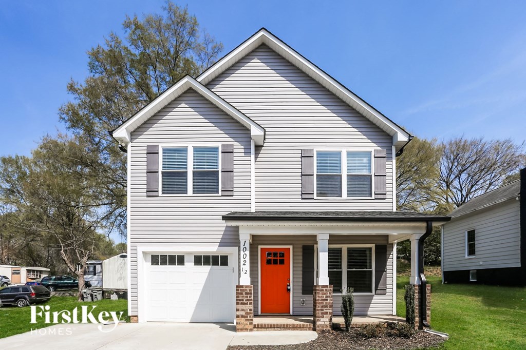 a white house with a red door and a white garage