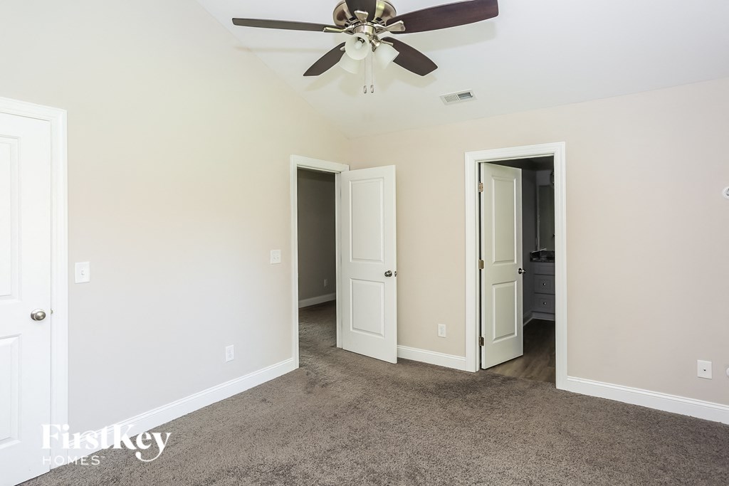 a living room with carpet and a ceiling fan