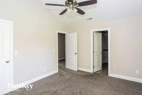 a living room with carpet and a ceiling fan