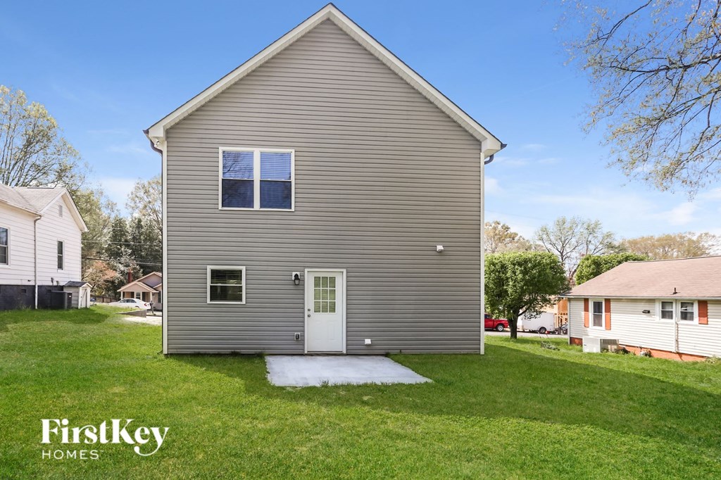 front view of a gray house with a white door and a grassy yard