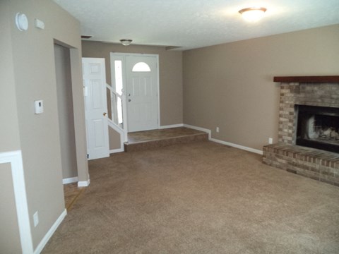 a living room with a fireplace and a carpeted floor