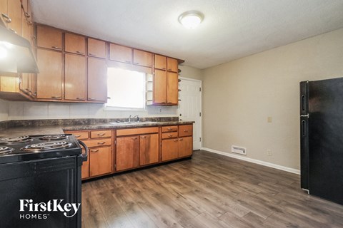 A kitchen with wooden cabinets and a black stove top.