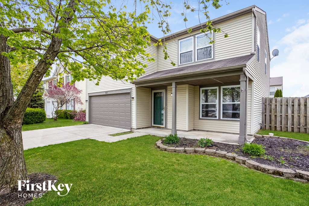a white house with a lawn and a driveway