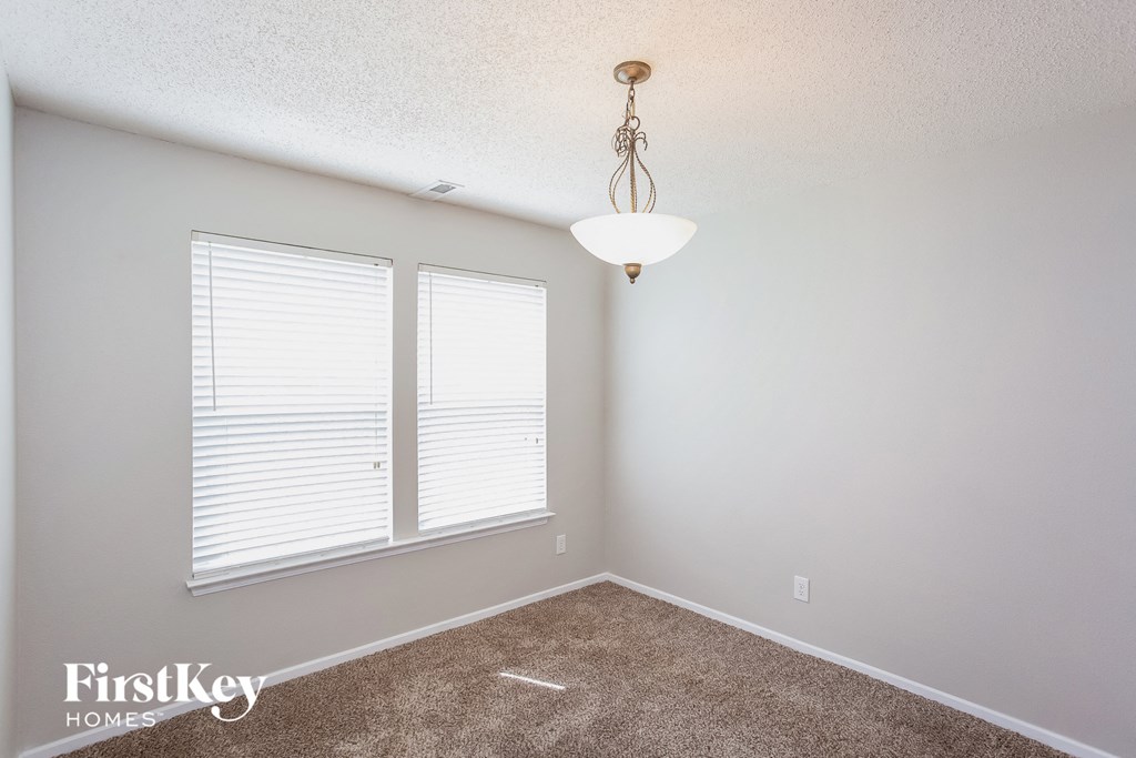 a bedroom with two windows and a carpeted floor