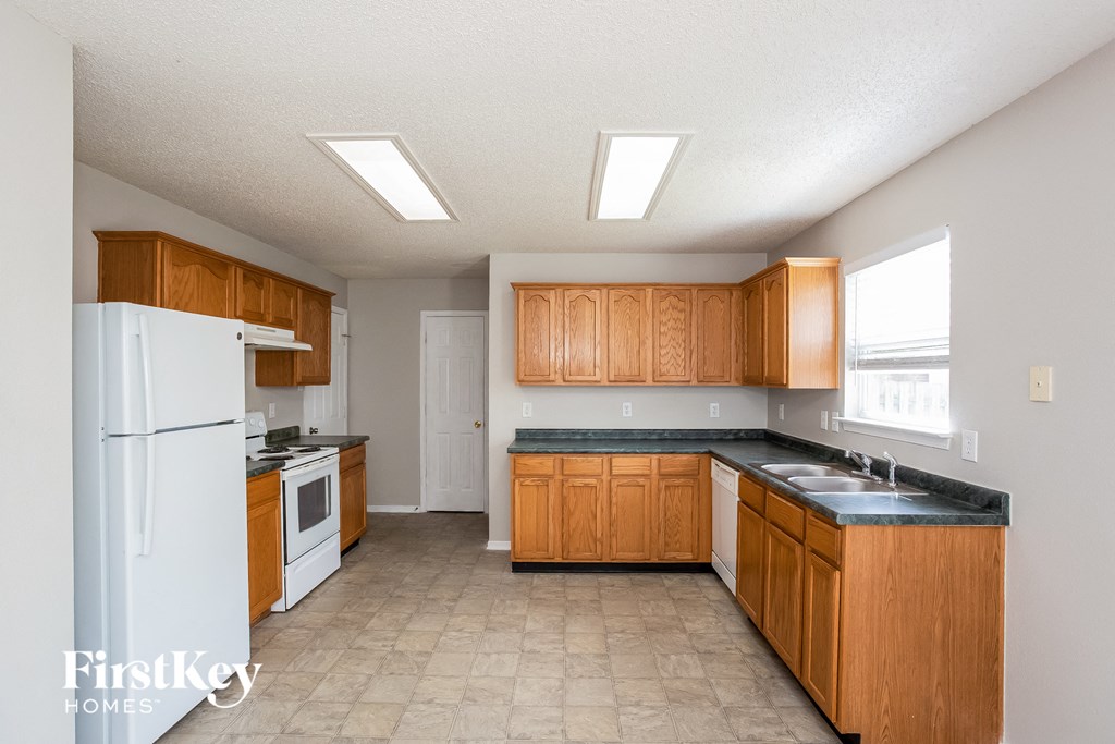 a kitchen with wooden cabinets and white appliances and a white refrigerator