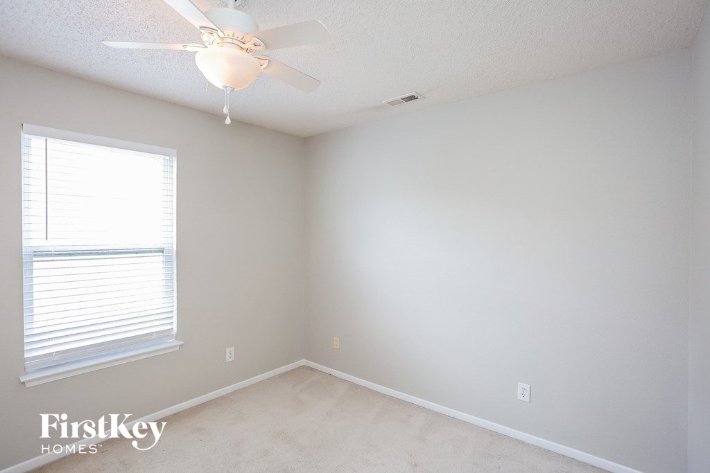 a bedroom with a ceiling fan and a window