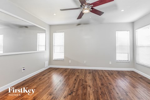 the living room with wood floors and a ceiling fan